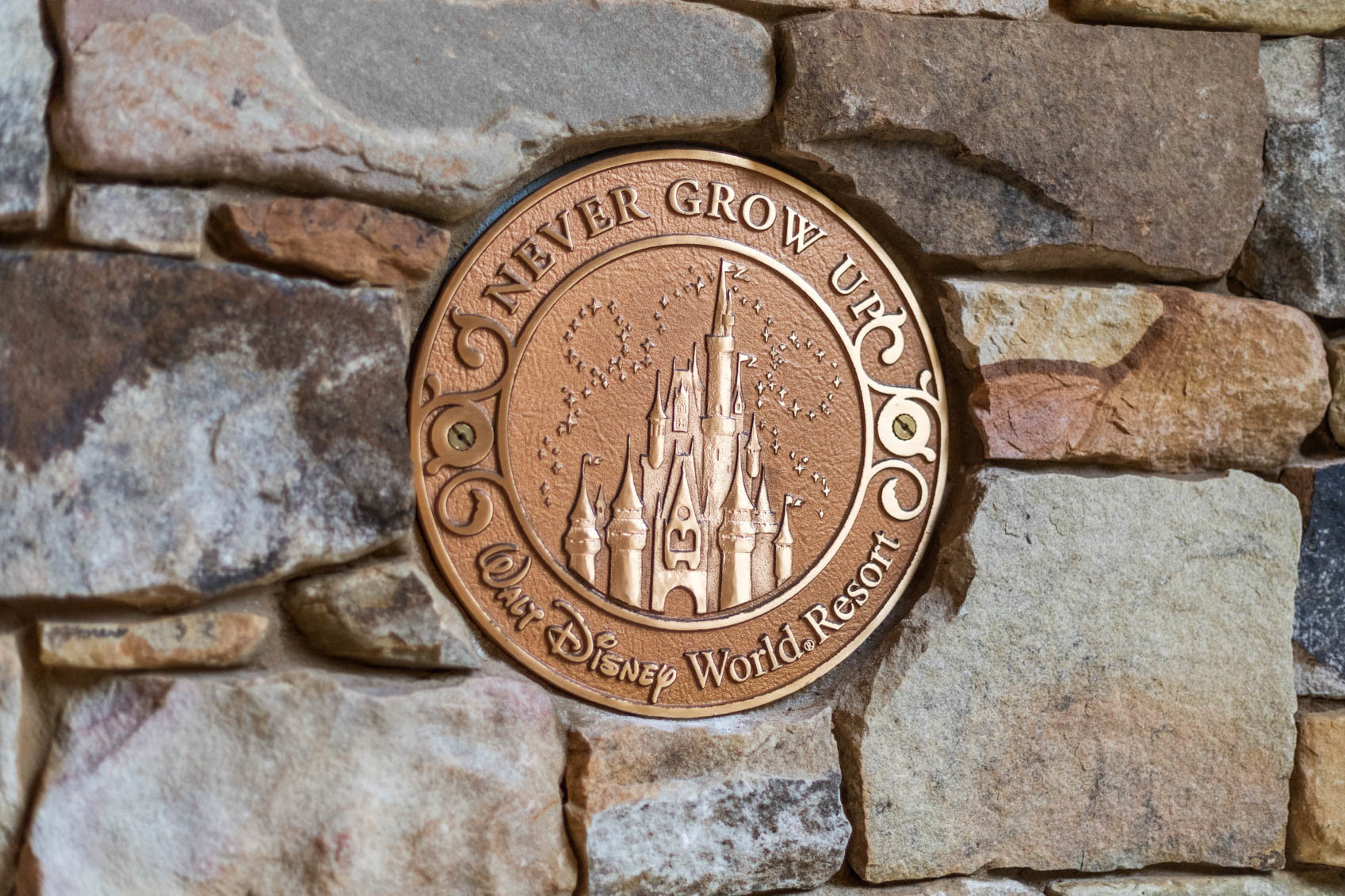 walt disney world crest on a brick wall